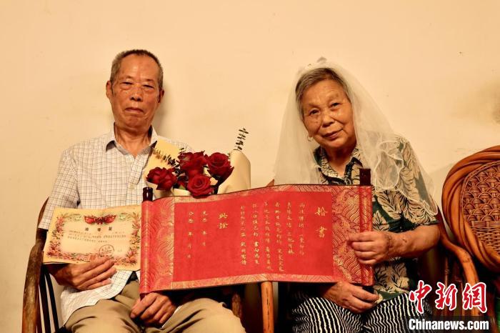 “钻石婚”夫妇拿着手写婚书